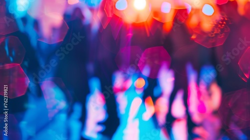 People dance in the blurred glow of club lights, immersing themselves in the vibrant nightlife of the party scene. © Vladimir
