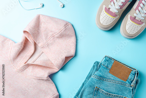 Outfit for teenagers on a blue background. Casual street style, top view point, flat lay.