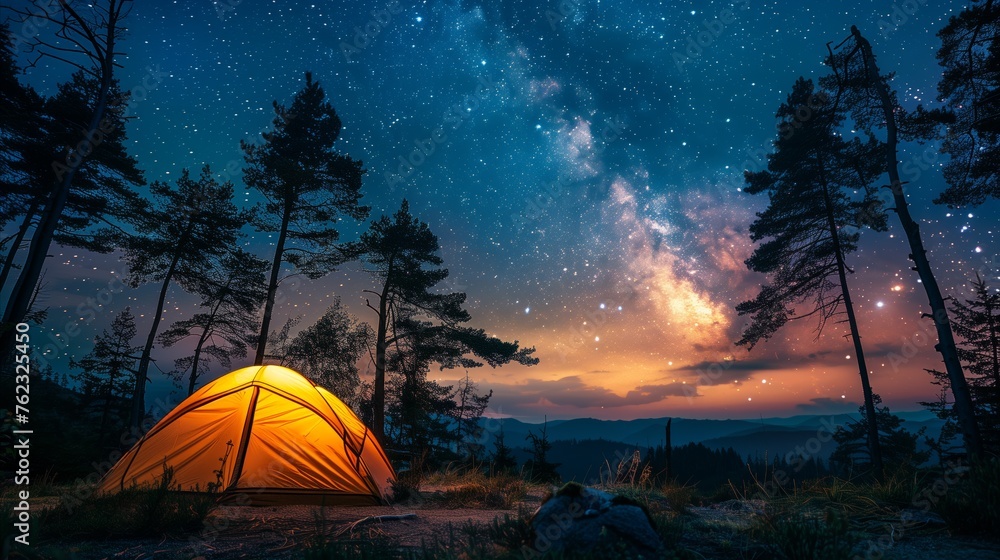 Illuminated tent under a starry sky in a forest
