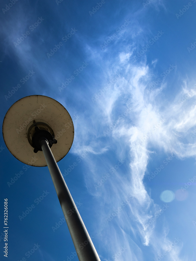 Cirrus oder Zirrus - eine reine Eiswolke vor blauem Himmel und einer Straßenlampe Cirrus oder Zirrus - eine reine Eiswolke vor blauem Himmel und einer Straßenlampe