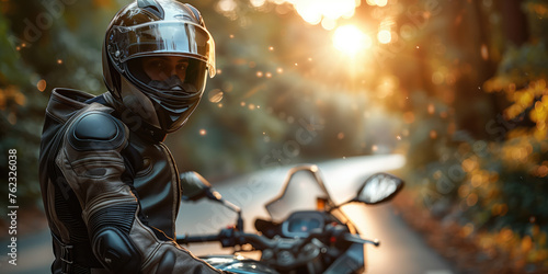 A motorcyclist clad in protective gear pauses on a forest road © Александр Марченко