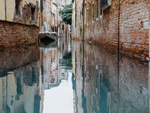 Canal in Venice with old stone walls and a single boat