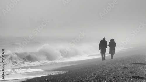 Couple strolling on a misty seaside in monochrome