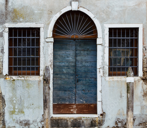 Arched doorway and windows with grilles on in Venice
