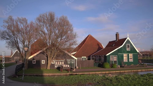 Traditional Dutch windmills in the rural landscape of Zaanse Schans village. Ancient houses brightly colored in spring season at sunset 4k