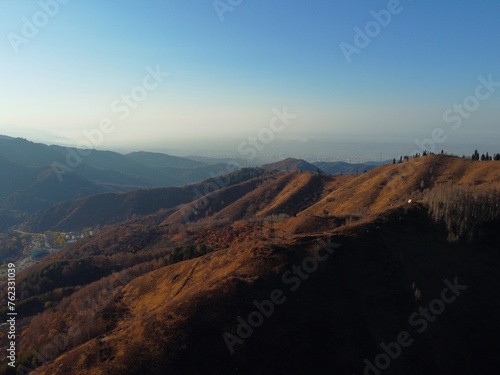 aerial View of mountain plateau and cliffs. Autumn photo of high-altitude landscape with trees. landscape at sunset in beautiful nature in the autumn season. orange, blue, gold colors