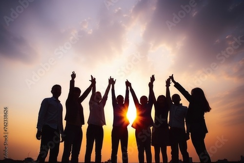 A group of people raising their hands in unity. Suitable for team building concepts