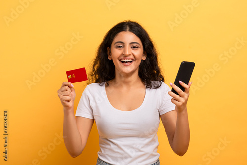Cheerful woman holding phone and credit card photo