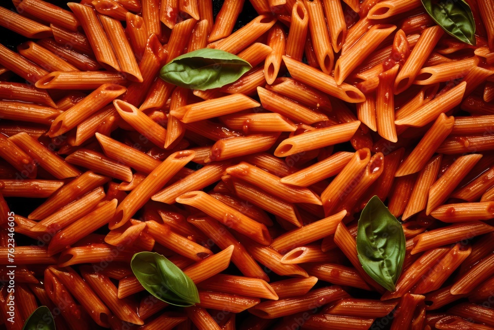 A delicious pile of pasta with sauce and fresh basil leaves. Perfect for food blogs and recipes A delicious pile of pasta with sauce and fresh basil leaves. Perfect for food blogs and recipes