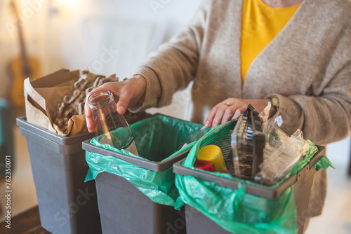 Fotografie Senior woman sorting garbage in recycling bins at home