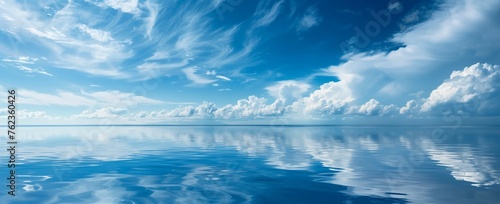 panoramic view of mirrorlike water surface under blue sky