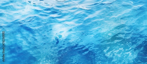 A close up of an electric blue water surface in a swimming pool, showcasing fluid patterns created by wind waves. Perfect for recreation and relaxation