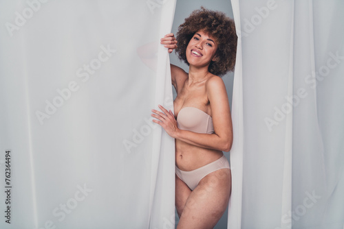 Unretouched photo of smiling girl hide from veil curtain advertising self love body concept isolated grey color background © deagreez