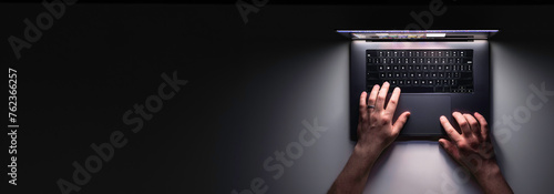 Man using laptop at night, top view, web banner with copy space.