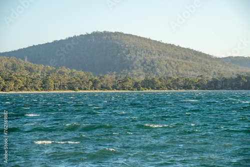 Beautiful Rocky Mountain over a lake in a beautiful park. Wilderness landscape with no people. Stunning bush and forest by the sea and ocean.