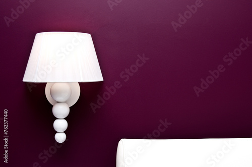 Elegant white wall lamp on deep red color background. Copyspace.