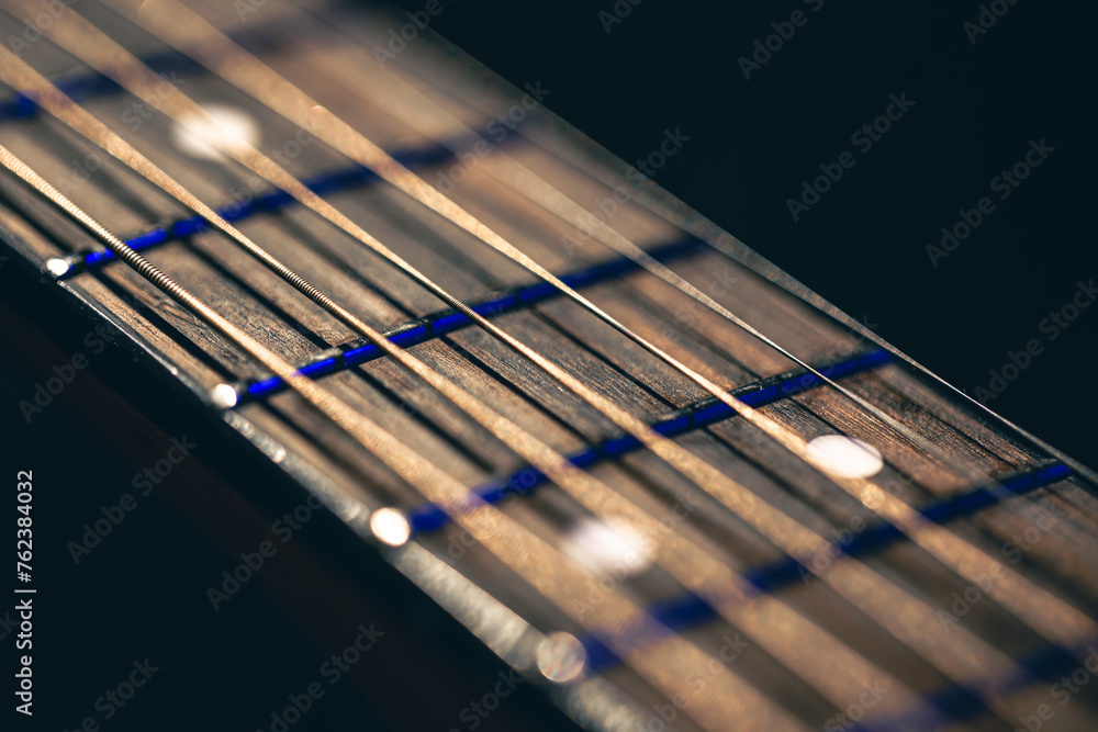 Part of an acoustic guitar, guitar fretboard on a black background. Part of an acoustic guitar, guitar fretboard on a black background.