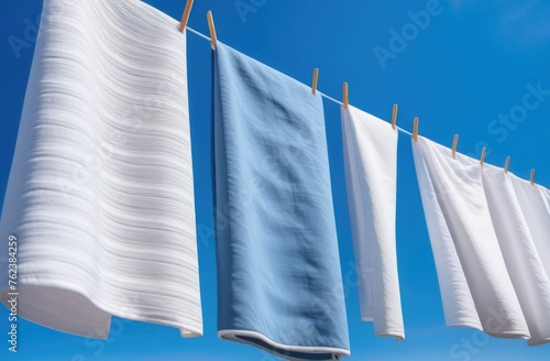 snow-white towels dry on a rope against a blue sky background