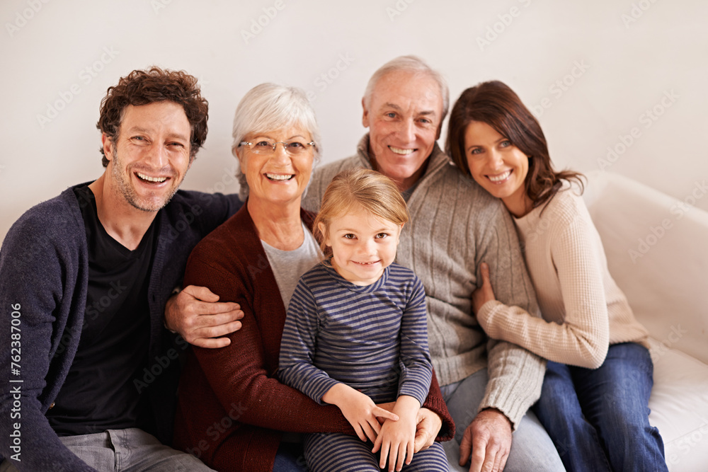 Grandparents, parents and child on sofa for portrait with hug, care or love with generations for bonding in home. Mother, father and senior people with kid for embrace on lounge couch in family house