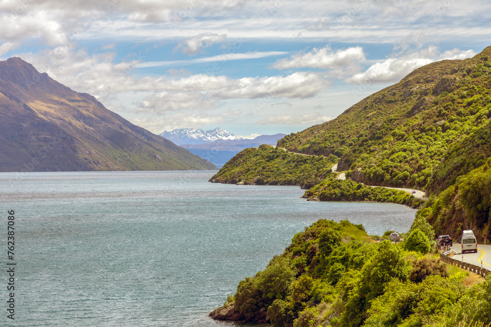 The scenic State Highway 6 meanders along a picturesque Lake Wakatipu towards Queenstown in southern New Zealand