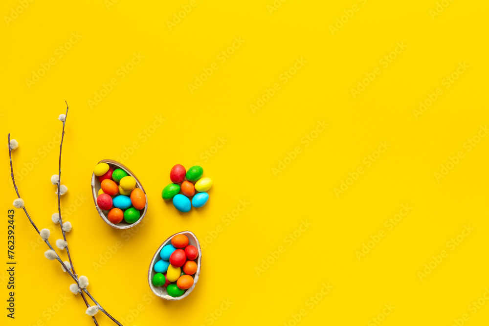 Happy Easter background with chocolate eggs and spring branch, top view - obrazy, fototapety, plakaty 