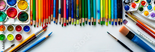 A variety of colorful art supplies neatly arranged on a white table, ready for a creative project