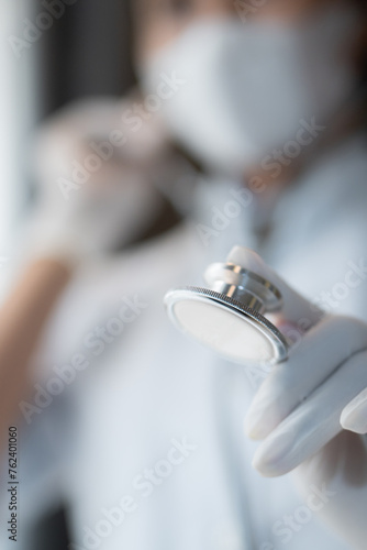 Healthcare and medical concept. Close-up of female doctor using stethoscope, focus on stethoscope