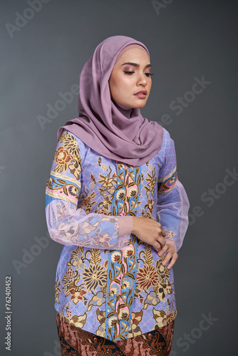 Beautiful female model wearing modern kebaya batik   an Asian traditional dress for Muslim woman isolated over grey background. Stylish Muslim female hijab fashion lifestyle portraiture concept