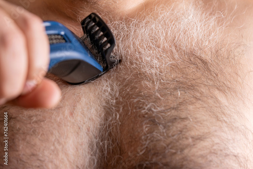 The thick gray hair on the man's chest is cut with a machine.