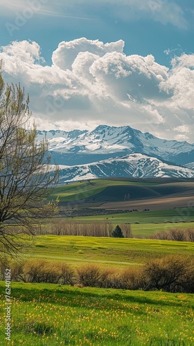 A beautiful mountain range with a cloudy sky in the background. The mountains are covered in snow and the sky is filled with clouds. The scene is peaceful and serene, with a sense of calmness