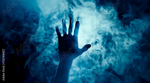 Silhouetted hands reaching out through a misty blue haze  creating a mysterious and eerie atmosphere