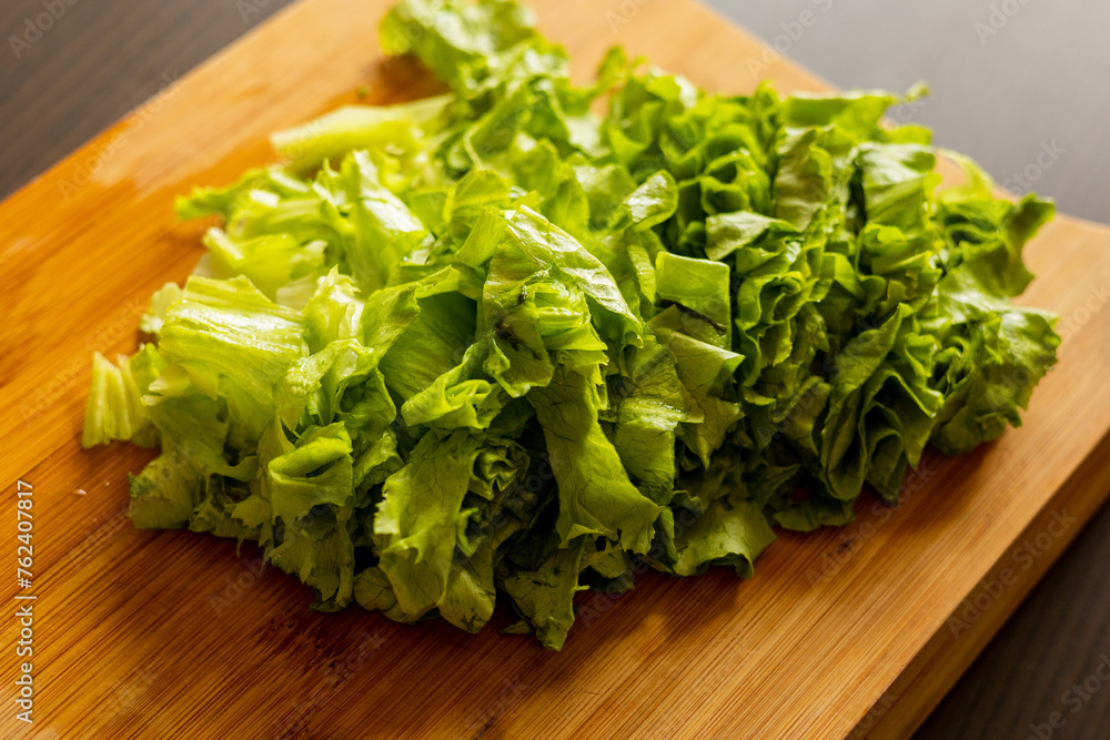 freshly cut lettuce on a wooden cutting board freshly cut lettuce on a wooden cutting board