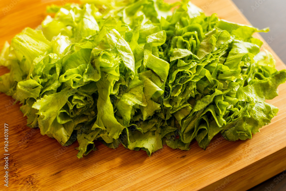 Close-up of freshly cut lettuce on a wooden cutting board Close-up of freshly cut lettuce on a wooden cutting board