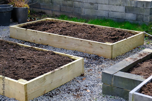 Fotografie Empty raised beds in a garden in spring. Gardening Concept.