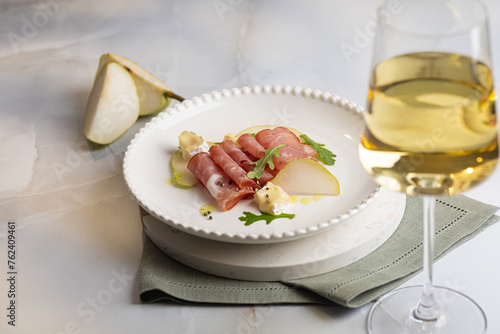 Fresh delicious salad with prosciutto, arugula with rose wine on light great marble background. Healthy diet concept. Italian cuisine. Vertical