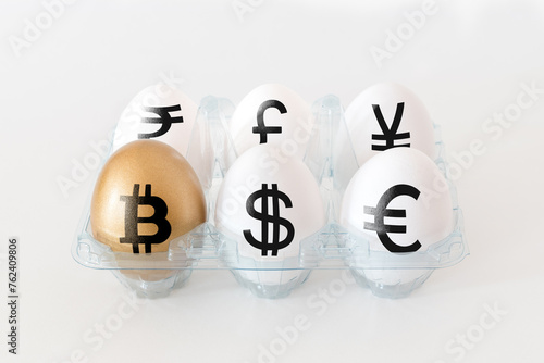 Golden egg with a bitcoin sign. Eggs with currency signs in packing on white background. Minimal investment concept.