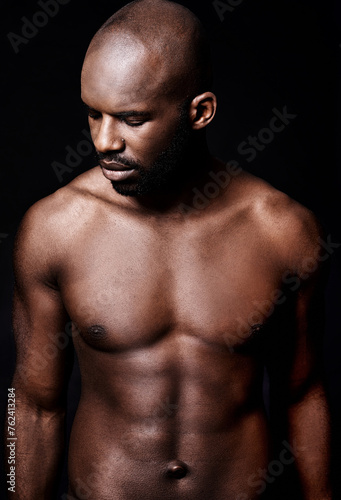 Black man, shirtless and body with six pack, fitness and health with muscle isolated on dark background. Exercise, sport and athlete with abs, confident and masculine with testosterone in studio