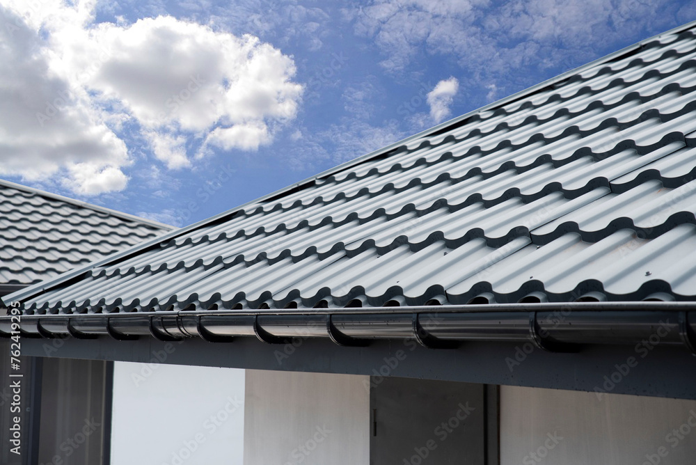 Corrugated metal roof tile and gutter on sky bacground Corrugated metal roof tile and gutter on sky bacground