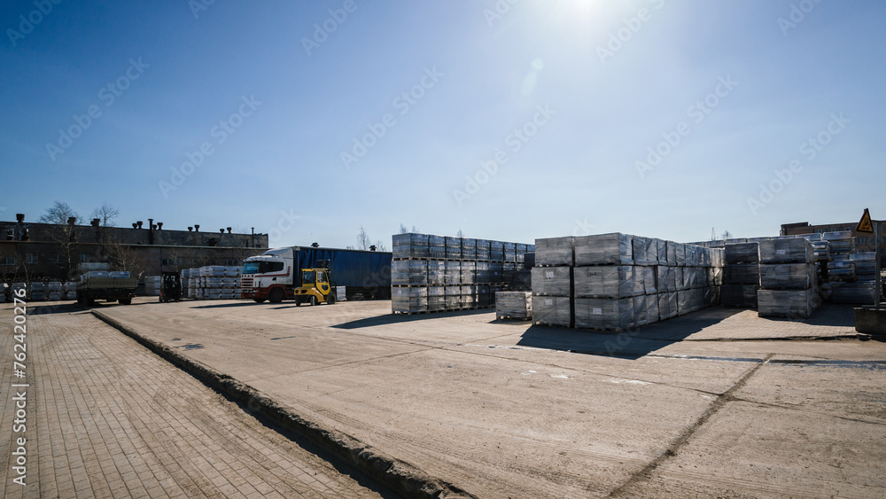  The loading bay is filled with trucks waiting to be loaded with the heavy pallets of finished goods and materials.