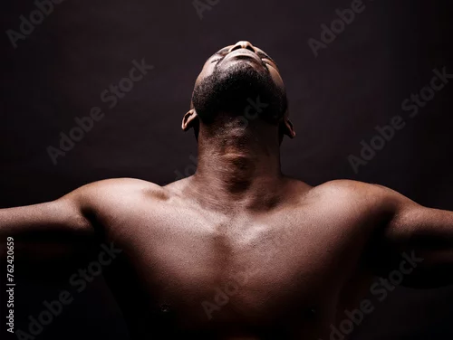 Obraz Looking up, stretching and man on black background with health, wellness and faith or praying in studio. Young person, athlete or African model in art deco with freedom, energy and peace or calm