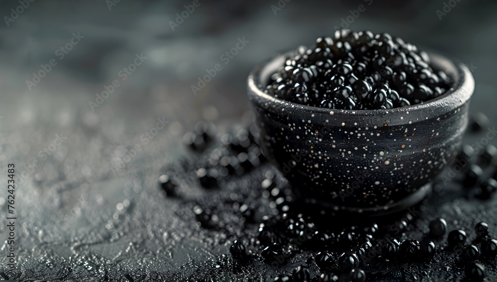 Black caviar in black ceramic bowl on dark background with copy space, luxurious taste concept. Premium sturgeon roe in a bowl on black background. Exclusive appetizer, source of omega-3 fatty acids - obrazy, fototapety, plakaty 