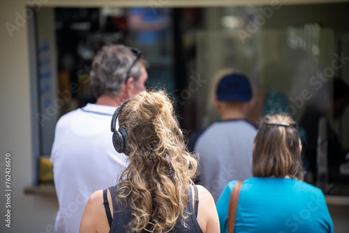 Girl lining up in a line for food at a cafe outdoors in a park. in australia photo