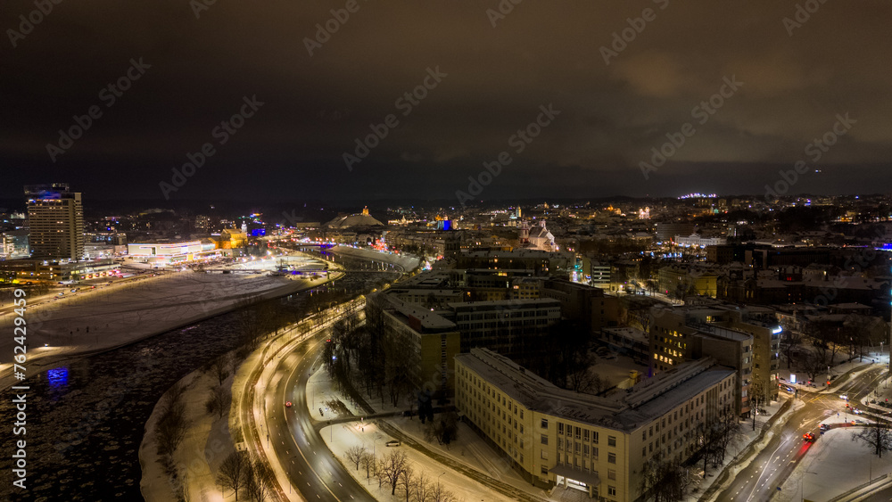 Drone photography of night city lights and river during winter night