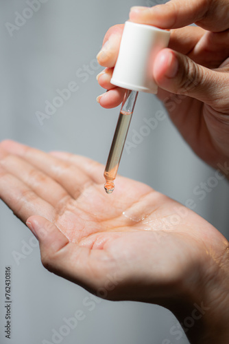 Woman using pipette with a hair tonic product 