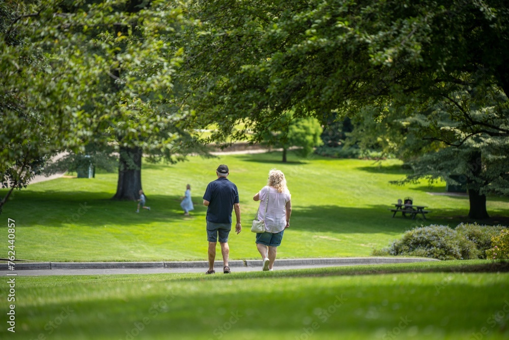 happy married couple walking in a green garden park exploring nature in a city happy married couple walking in a green garden park exploring nature in a city