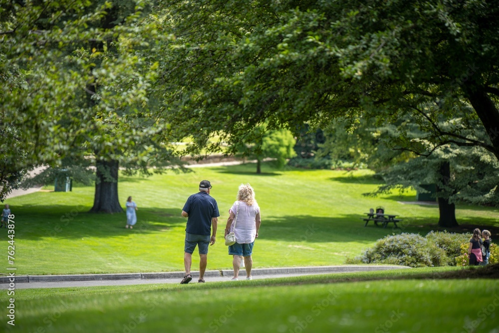 happy married couple walking in a green garden park exploring nature in a city happy married couple walking in a green garden park exploring nature in a city