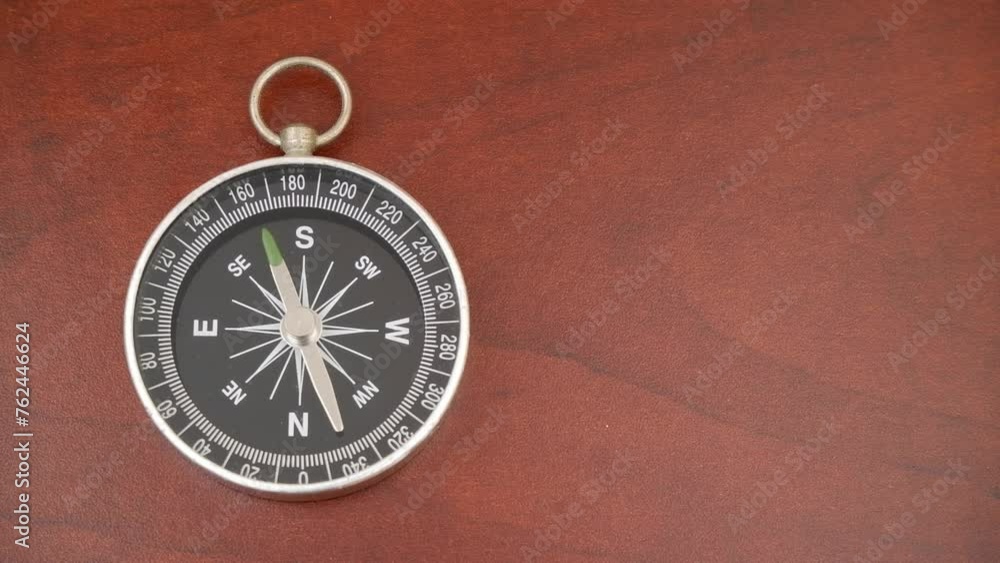 Compass on table with rotating pointer, copy space for text. Compass on table with rotating pointer, copy space for text.