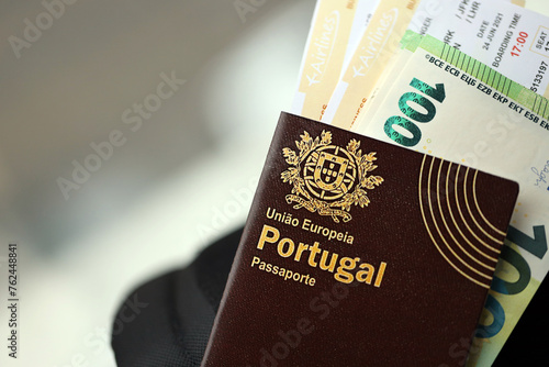 Red Portugal passport of European Union with money and airline tickets on touristic backpack close up. Tourism and travel concept photo