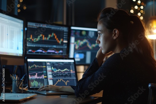 woman working on computer at digital trading studio using business laptop in front of computer screens