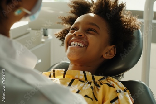 girl sitting in dentist chair laughing with dentist